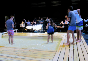 The cast rehearses a water scene in the Black Box.